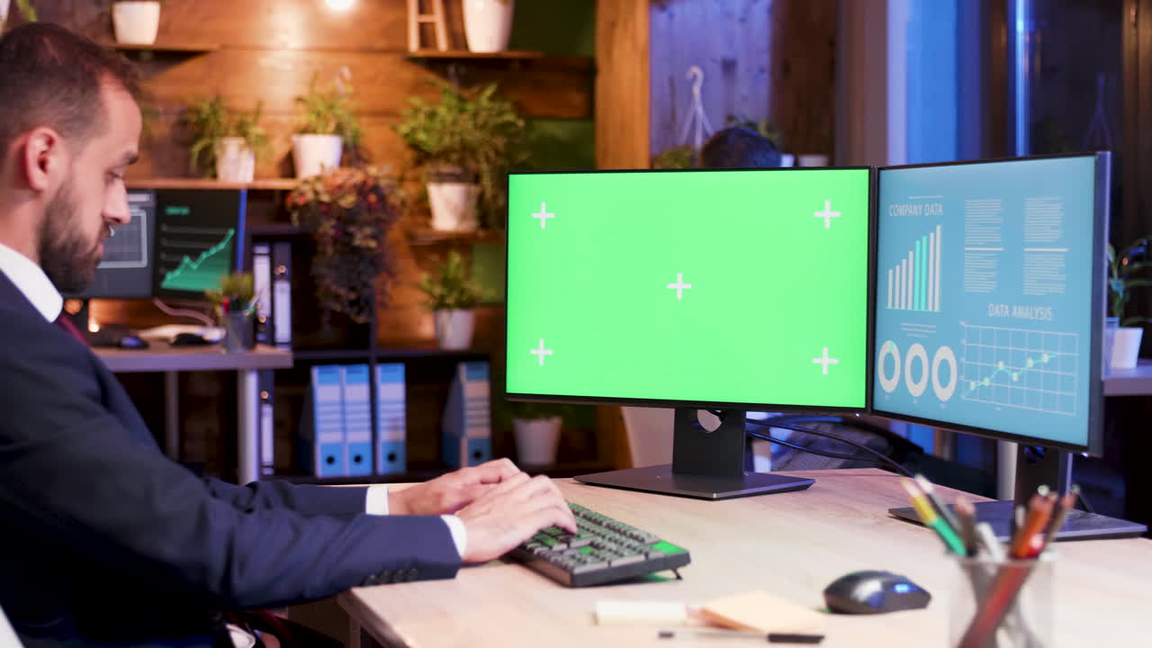 hombre trabajando en la computadora con pantalla verde