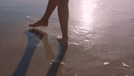 close up woman feet walking barefoot on beach at sunset leaving footprints in sand female tourist on summer vacation