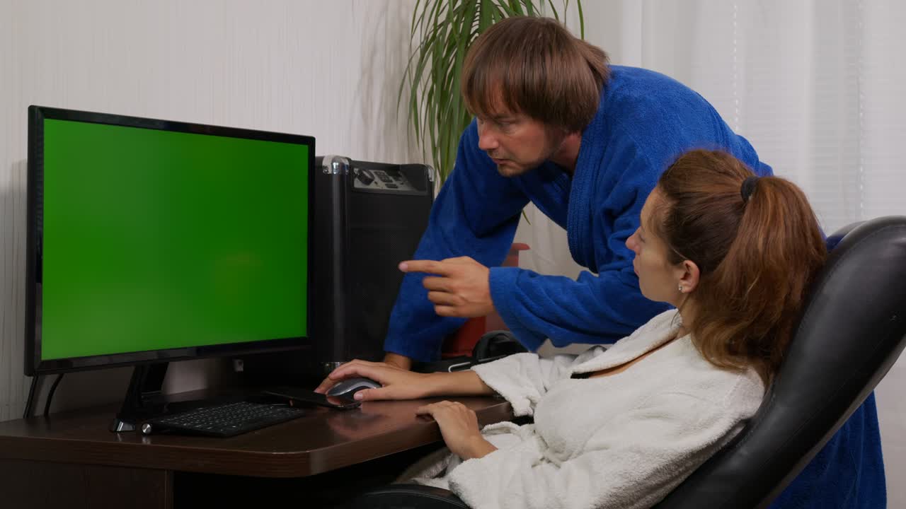 hombre de negocios y mujer de negocios en ropa de casa en casa con pantalla verde chroma clave pc en la mesa.