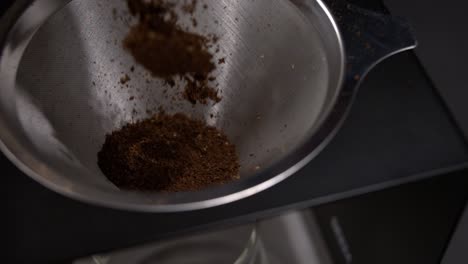 café molido cayendo en un vertido sobre la cafetera en súper cámara lenta
