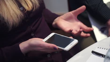 woman holding phone during meeting