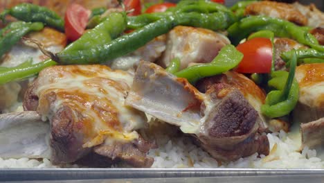 meat ribs with melted cheese, green peppers, and rice