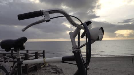 vintage '80s touring bicycle by the sea with sunset in the back slow motion 120 fps - orbiting front shot