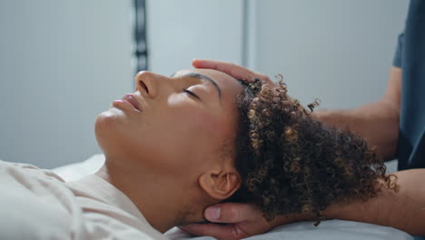 closeup patient lying massage session. physiotherapist hands pressing woman head