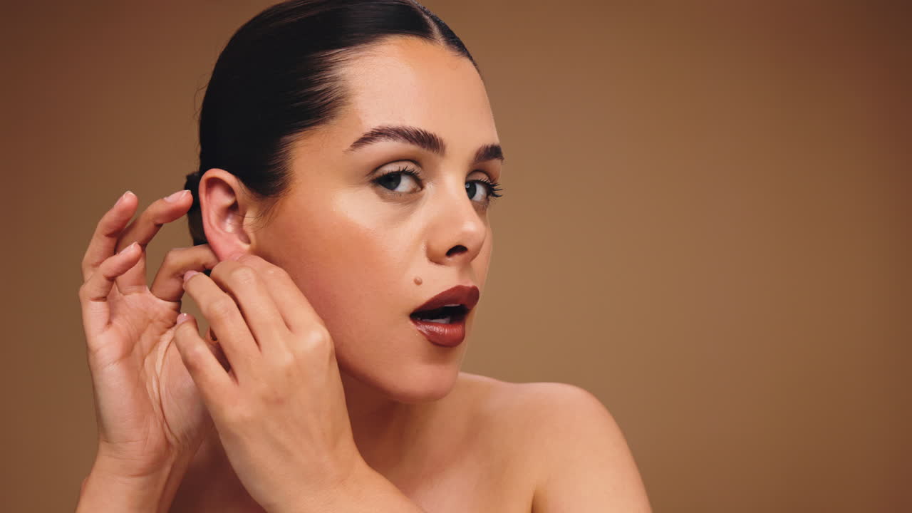 Beauty portrait of a woman with makeup and gold earrings