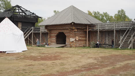 Medieval-courtyard-with-wooden-arch-near-gate-and-white-tent