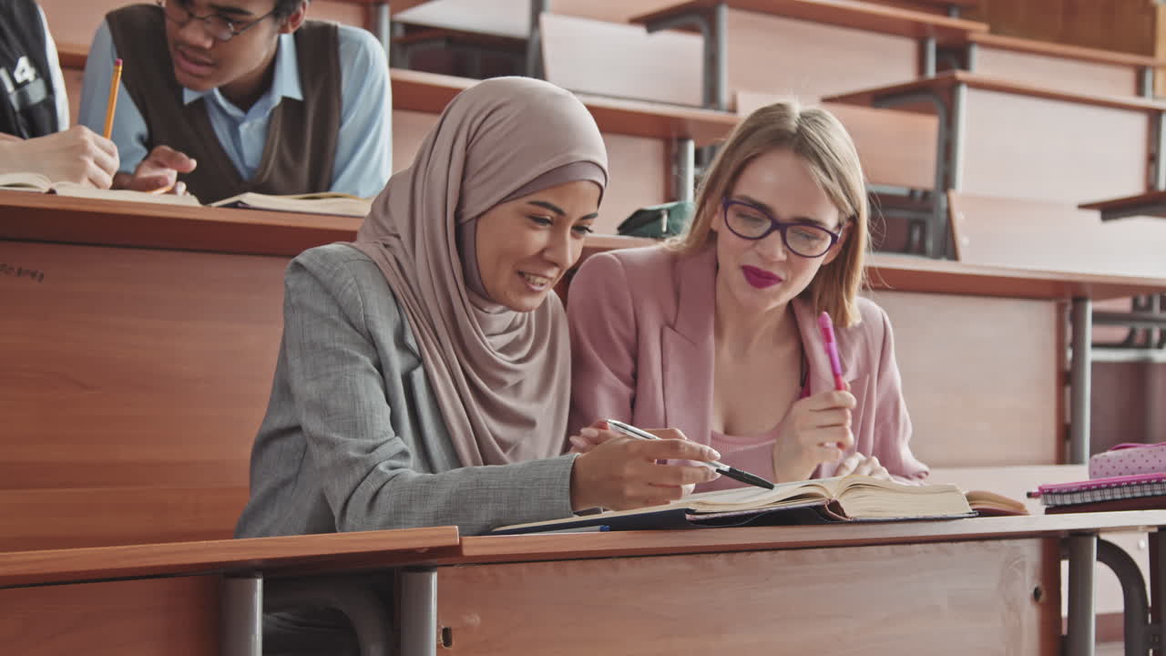 Due studentesse che parlano durante la lezione