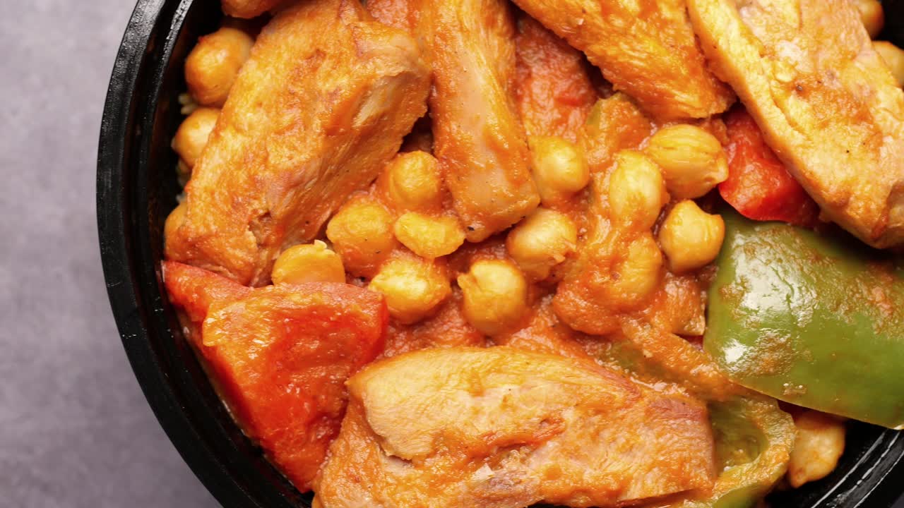 Pollo al curry y arroz en un paquete de plástico para llevar en la mesa