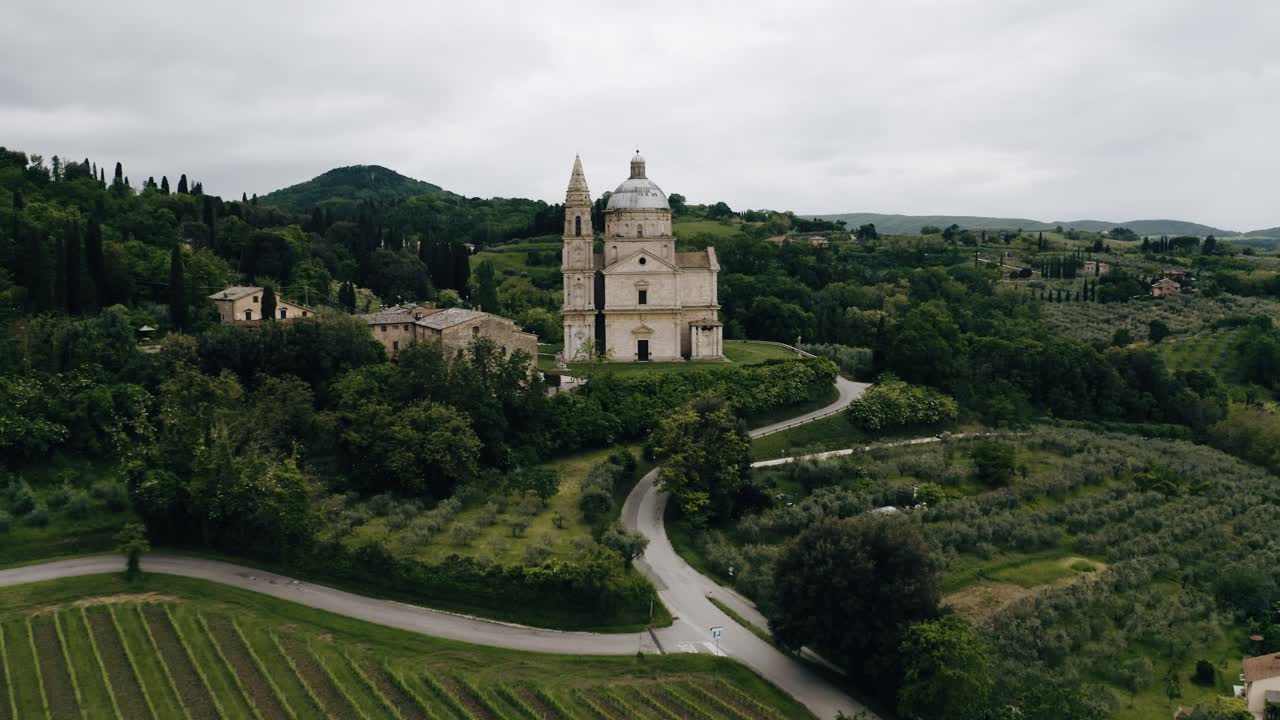 Drone shot flying by Italy's Sanctuary of the Madonna di San Biagio amidst a green countryside backdrop