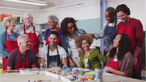 portrait of mature and senior adults attending art class in community centre with teacher