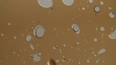 toma macro de pequeñas burbujas moviéndose en un líquido transparente dorado