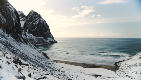 wintersonnenuntergang über dem strand von kvalvika und schroffen berggipfeln auf den lofoten, norwegen - luftaufnahme