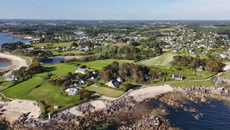 Scenic-aerial-view-of-a-coastal-town-with-rocky-shores-and-green-fields