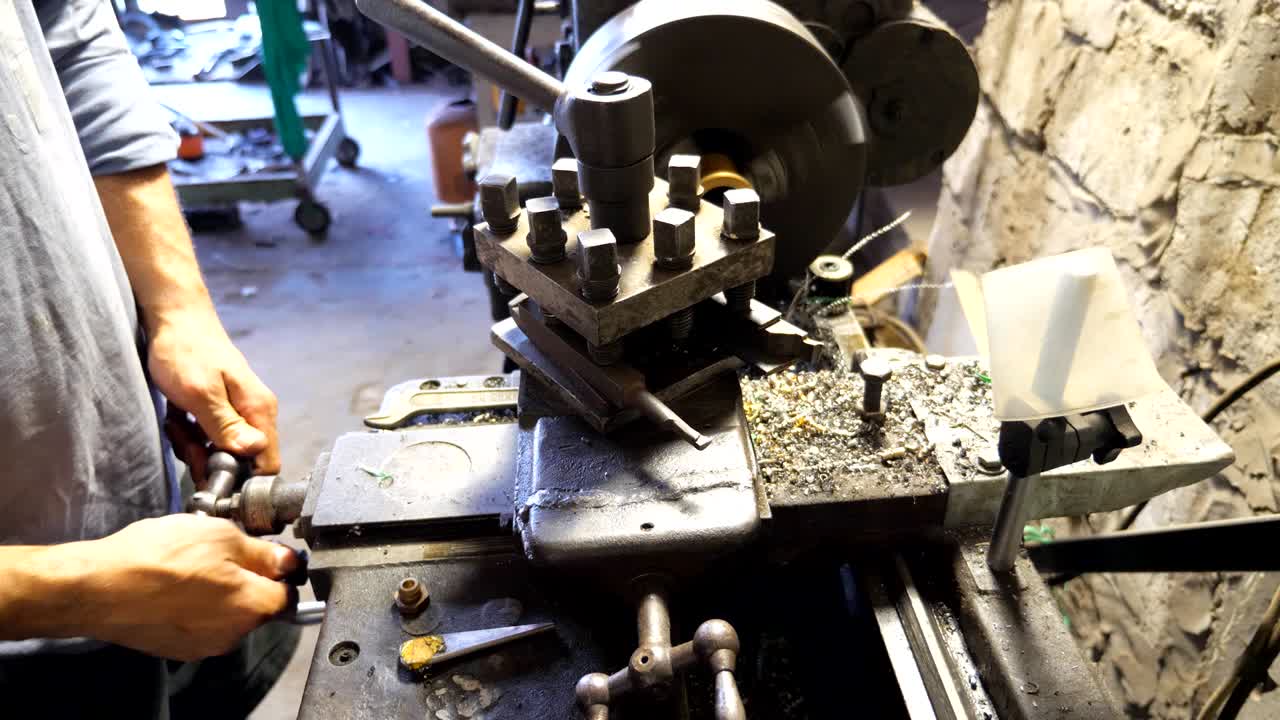 작업 중인  또는 밀링 머신: 차고 또는 워크에서 오래된 작업 벤치와 함께 일하는 인식 할 수없는 터너; 금속 가공을 위해 도자기를 사용하는 메카닉; 느린 동작.