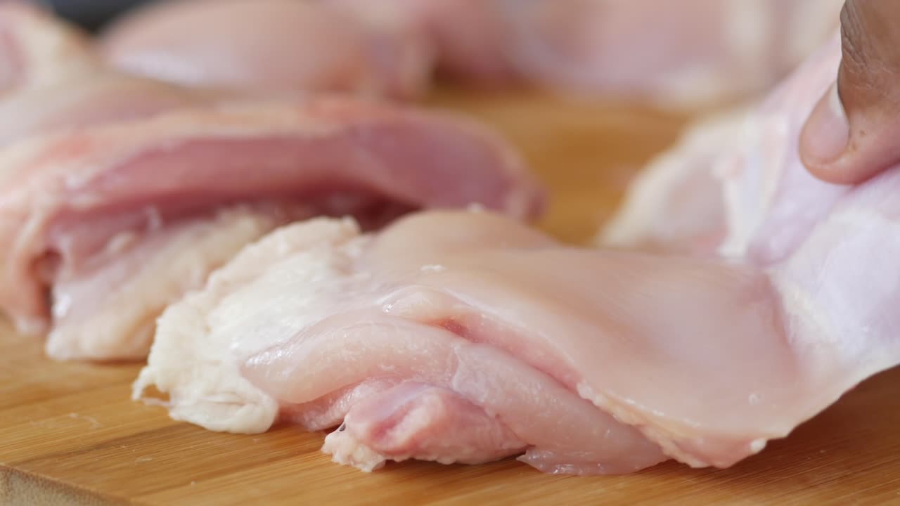 Close up of raw chicken pieces on a cutting board