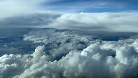 awesome aerial view taken from a jet cockpit during cruise level in a turbulent sky penty of cumolus and cumulonimbus