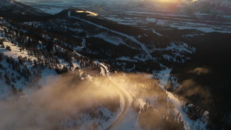 Teton-Pass-Wyoming-Pn-Puesta-De-Sol-De-Invierno,-Vista-Aérea-Del-Paisaje-Nevado-Y-Nubes-Sobre-La-Carretera