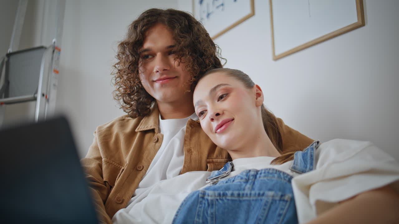 Romantic couple resting home couch looking each other with love closeup