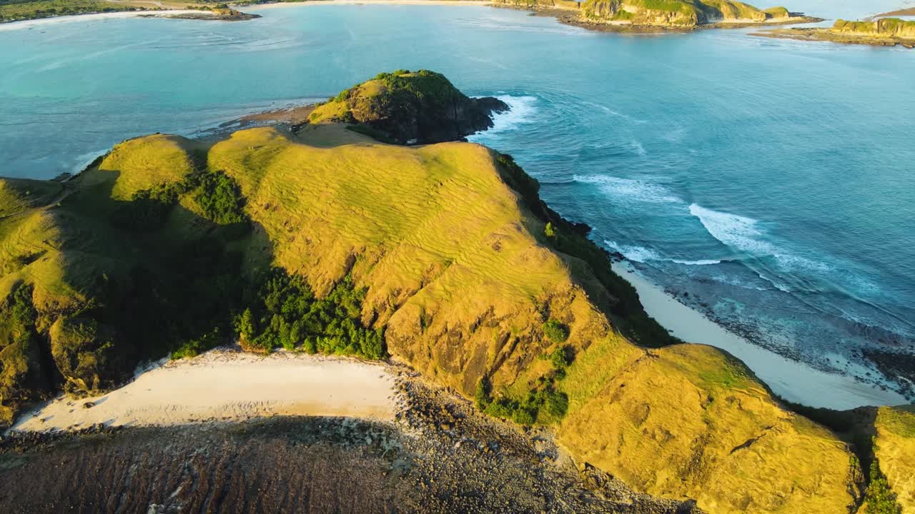 인도네시아의 롬복 섬에서 유명한 부키트 메레스 언덕과 모래 해변과 바다에서 불어오는 파도가 있는 공중 도 촬영.