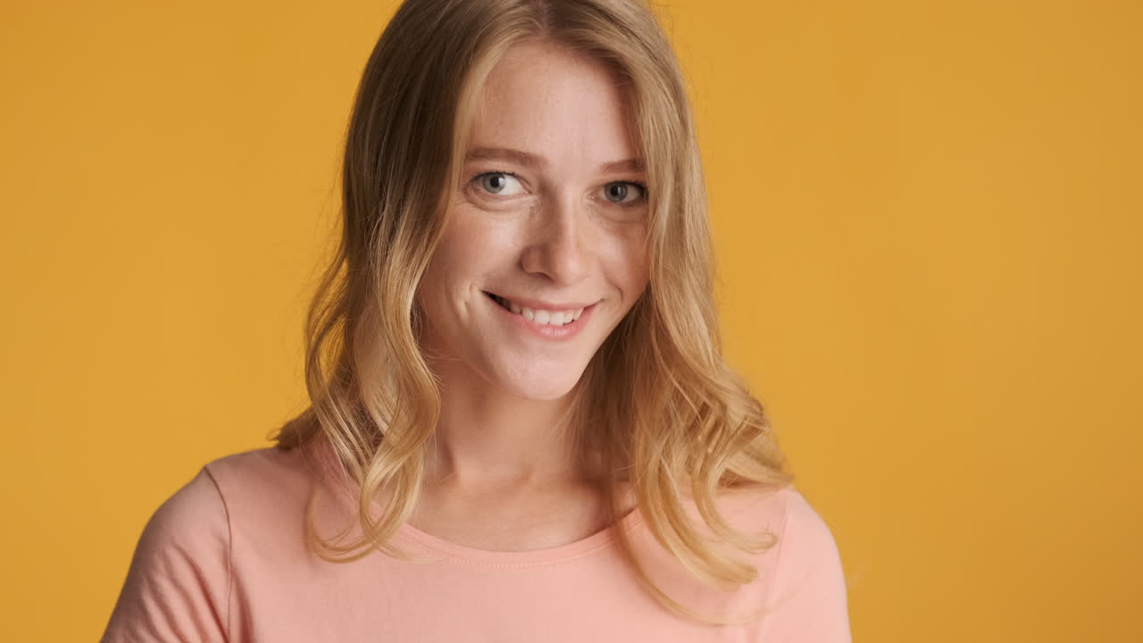 Caucasian woman showing flirting gestures on camera.