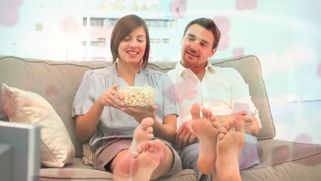 couple eating pop corn on sofa with pink heart animation