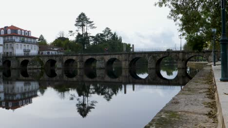 Puente-Romano-De-Aquae-Flaviae-En-Chaves,-Vila-Real,-Portugal-Se-Refleja-En-El-Agua-Debajo.