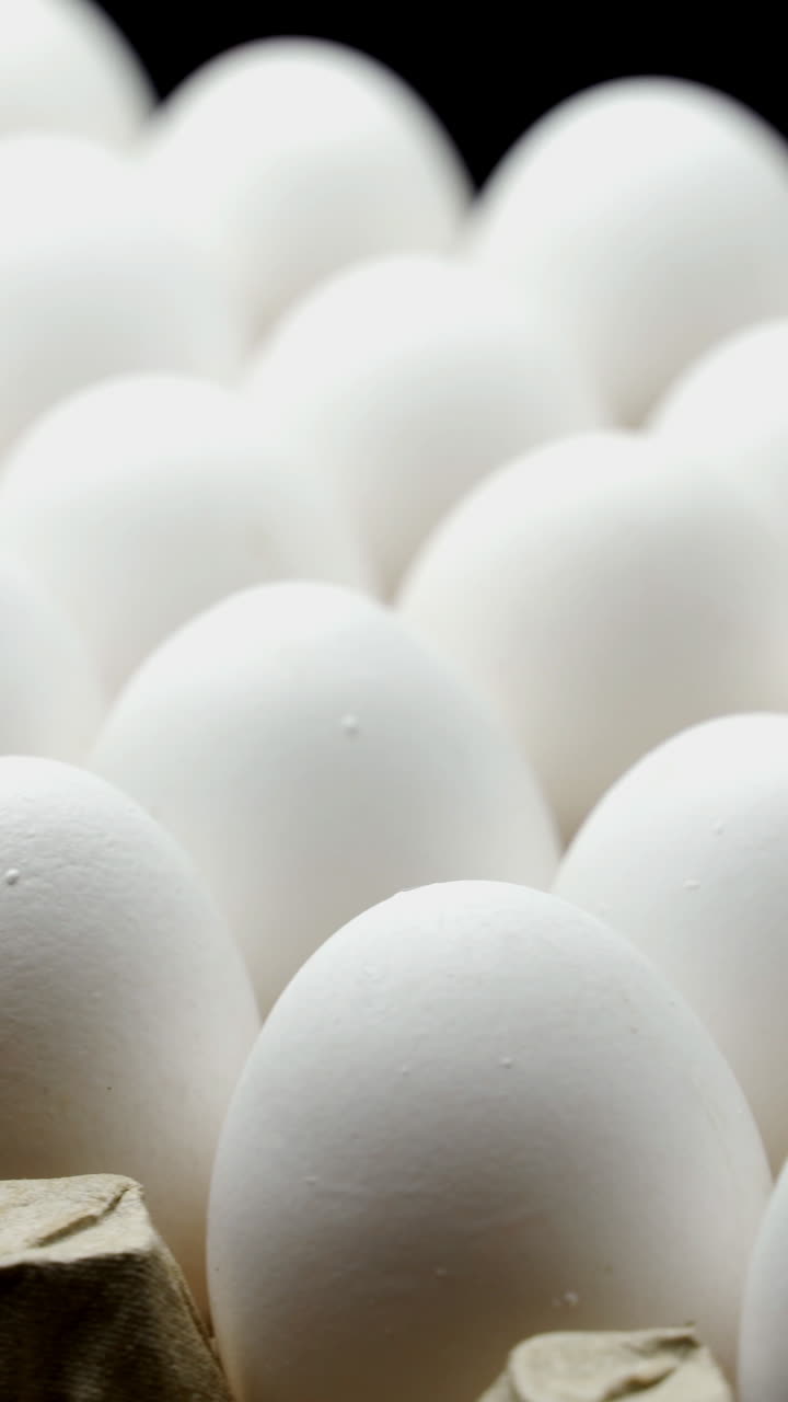 White chicken eggs in a cardboard box. Eggs in the container Vertical video