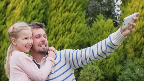 Smiling-father-and-daughter-making-funny-faces-while-taking-selfie-4K-4k