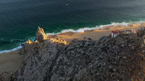 disparo de drones sobre una montaña que revela la playa en cabo san lucas méxico