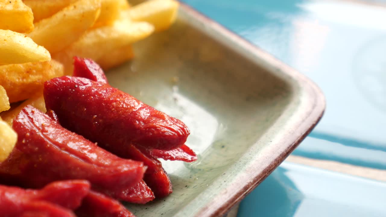 primer plano de papas fritas y salchichas en un plato