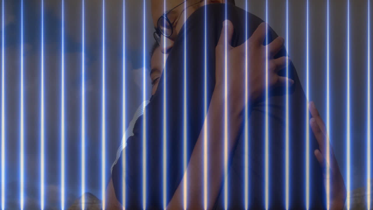 Pareja abrazándose cálidamente con haces de luz verticales azules y efecto de animación.