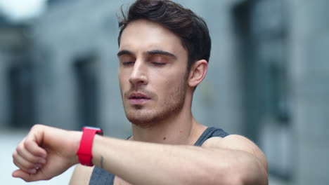 closeup male athlete using smart clock outside. fit man setting smart watch