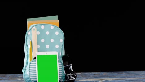 schoolbag and digital tablet arranged on table