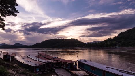 Barcos-Turísticos-Estacionados-En-El-Mekong-En-El-Sudeste-Asiático-Con-El-Sol-Poniente-Y-Las-Nubes