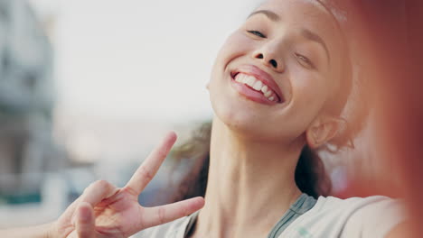 mujer feliz, cara y signo de paz en la ciudad