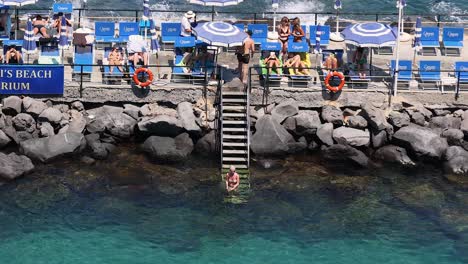 people swimming and relaxing by the beach