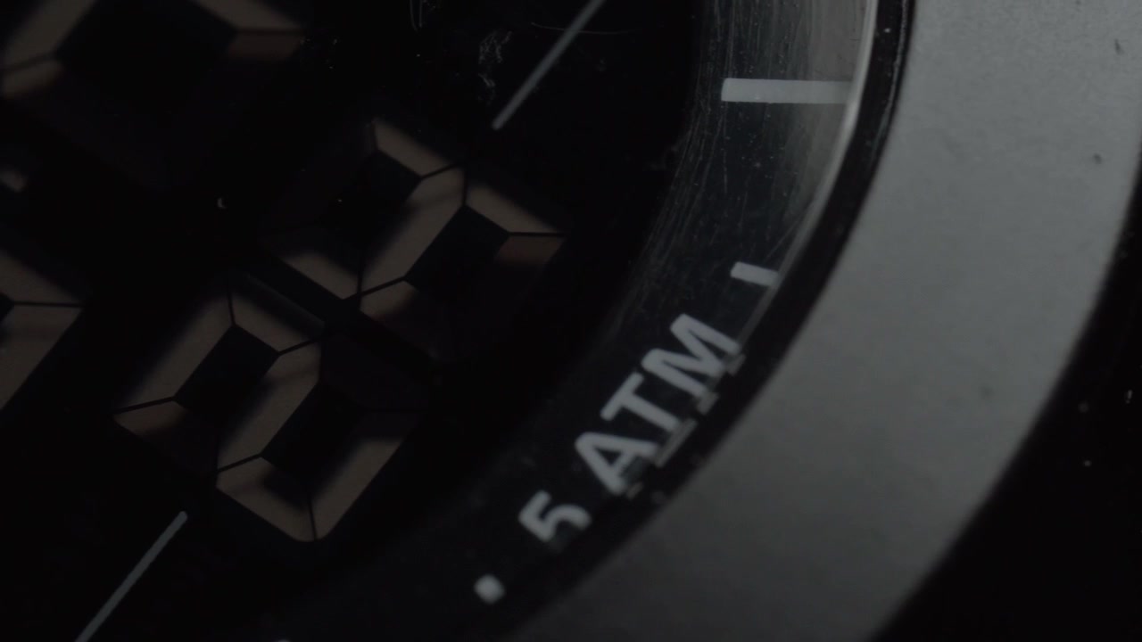 Ripresa panoramica del display di un orologio da polso digitale che mostra numeri illuminati, evidenziando cifre segmentate, superficie scura dell'orologio e display elettronico dell'ora in primo piano