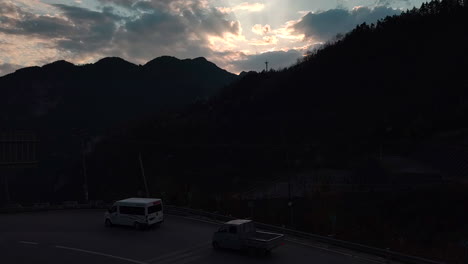 저녁 에 산 의 시골 도로 에서 운전 하는 차량 들