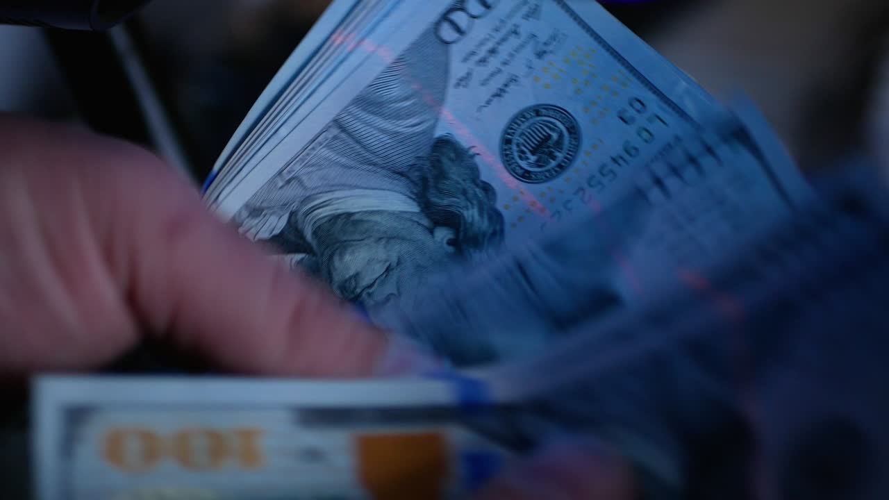 Dollar Bills in the ultraviolet light. Concept - checking dollars for authenticity. Search for watermarks on banknotes.