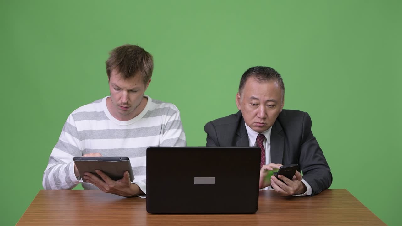 성숙한 일본 사업가와 젊은 스칸디나비아 사업가가 함께 일하고 있습니다.