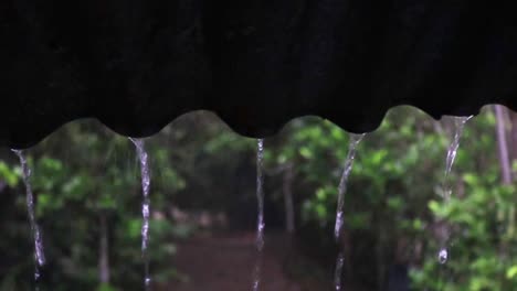 rain pours off a roof during a rainstorm