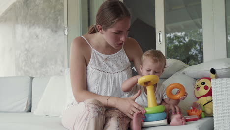 caucasian toddler playing with toy pyramid