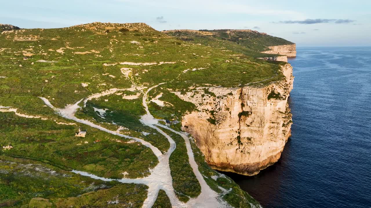 Soar over the breathtaking cliffs and plateaus of Miġra l-Ferħa, revealing the interplay of rugged geology and serene Mediterranean waters.