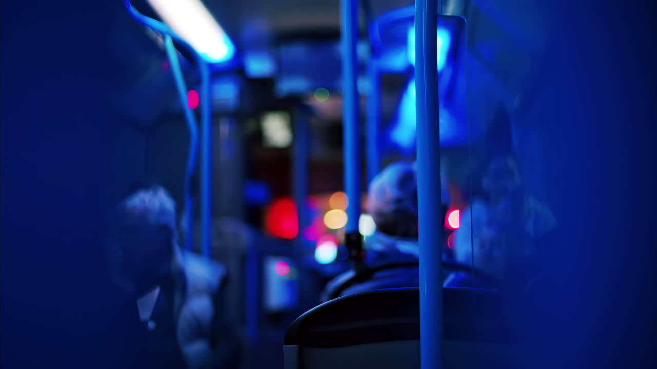 People sitting in a moving train in the evening with blue lighting