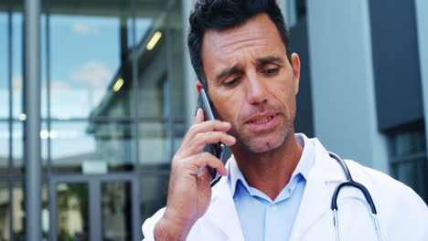 el médico habla por teléfono móvil.