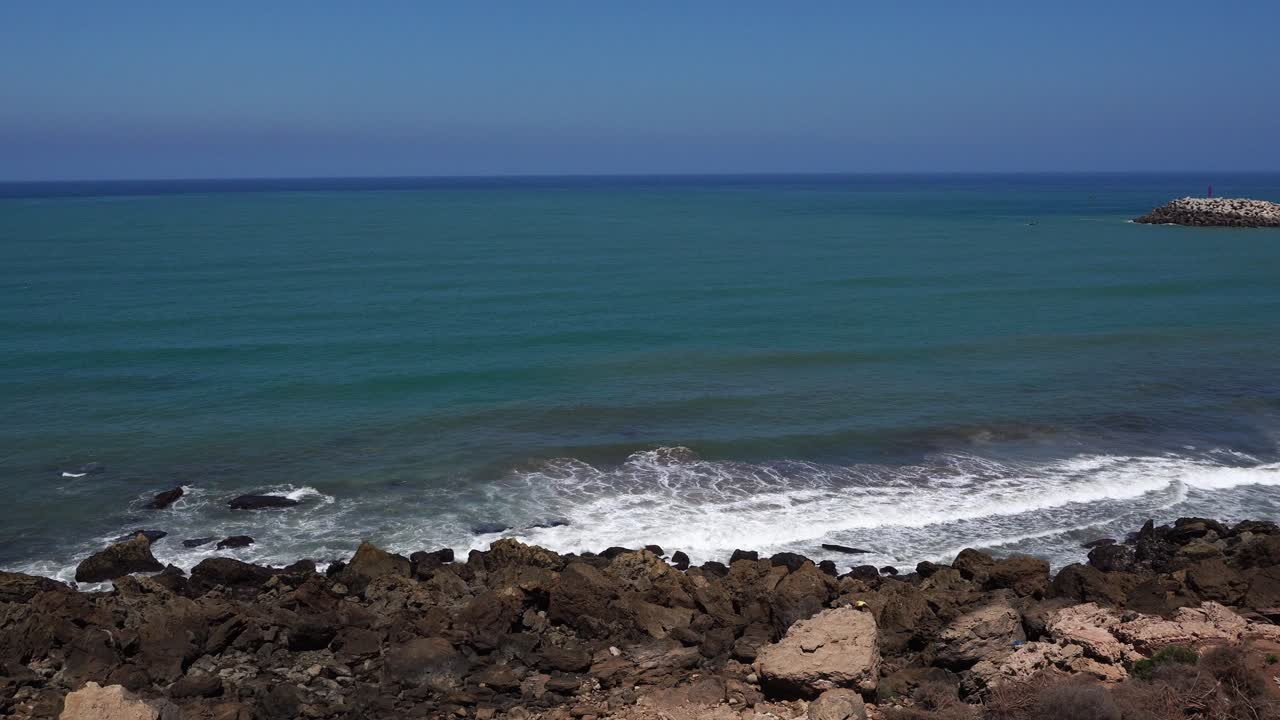The sea waves gently strike the shore, where clusters of rocks look truly wonderful. In the distance, the endless blue is really beautiful