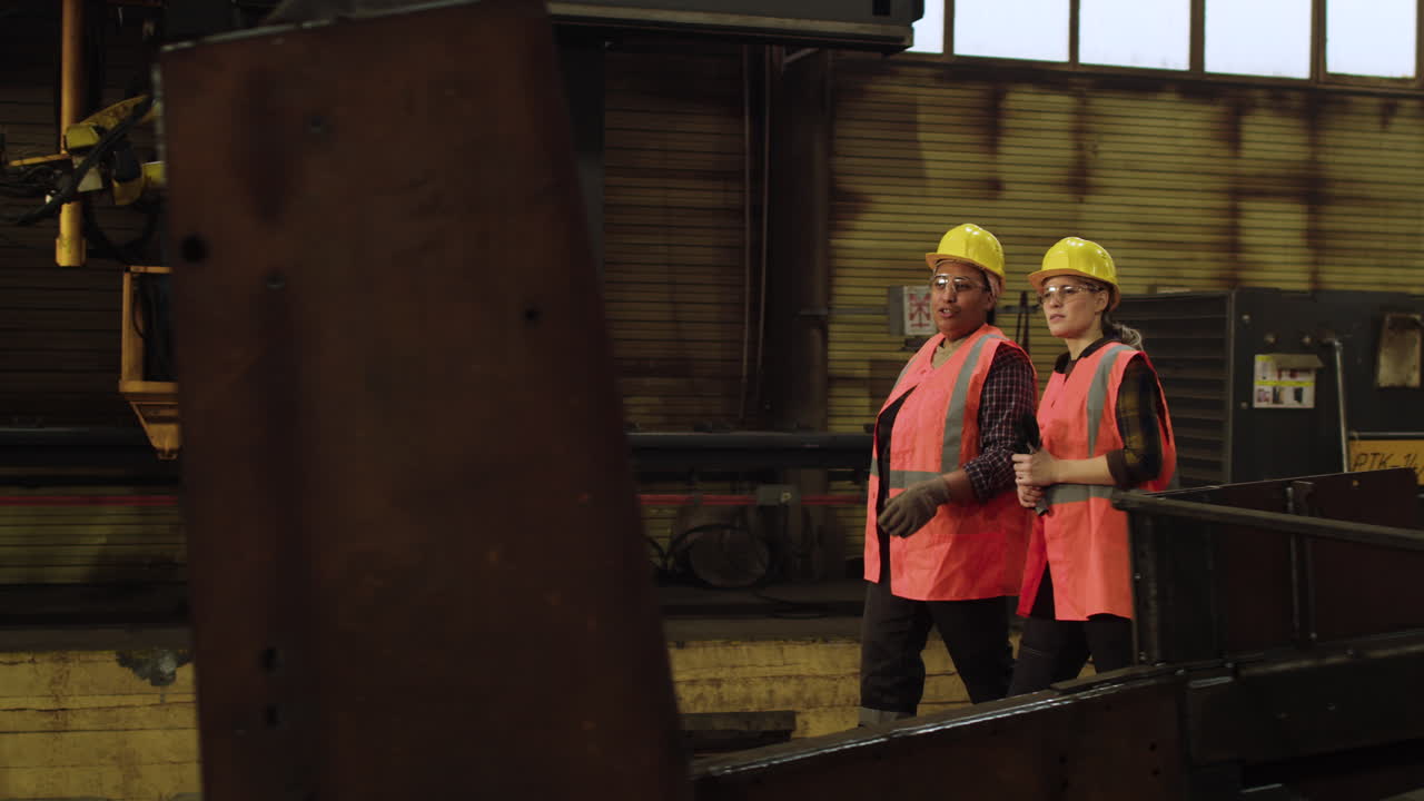 женщина проходит через фабрику.