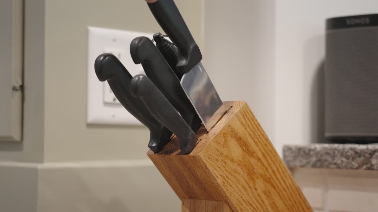 Drawing out a large knife from the block.