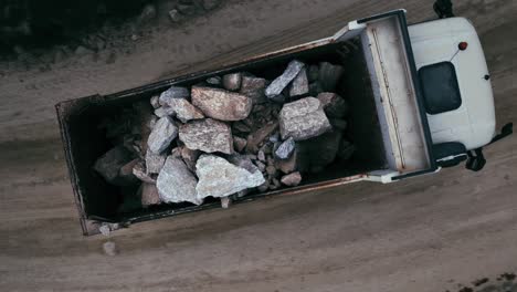 an aerial view of heavy rocks being transported in a large dump truck. 2