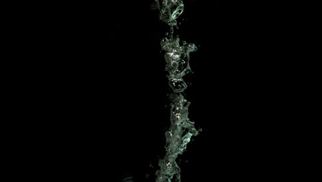 pimienta de chile cayendo en el agua sobre un fondo negro